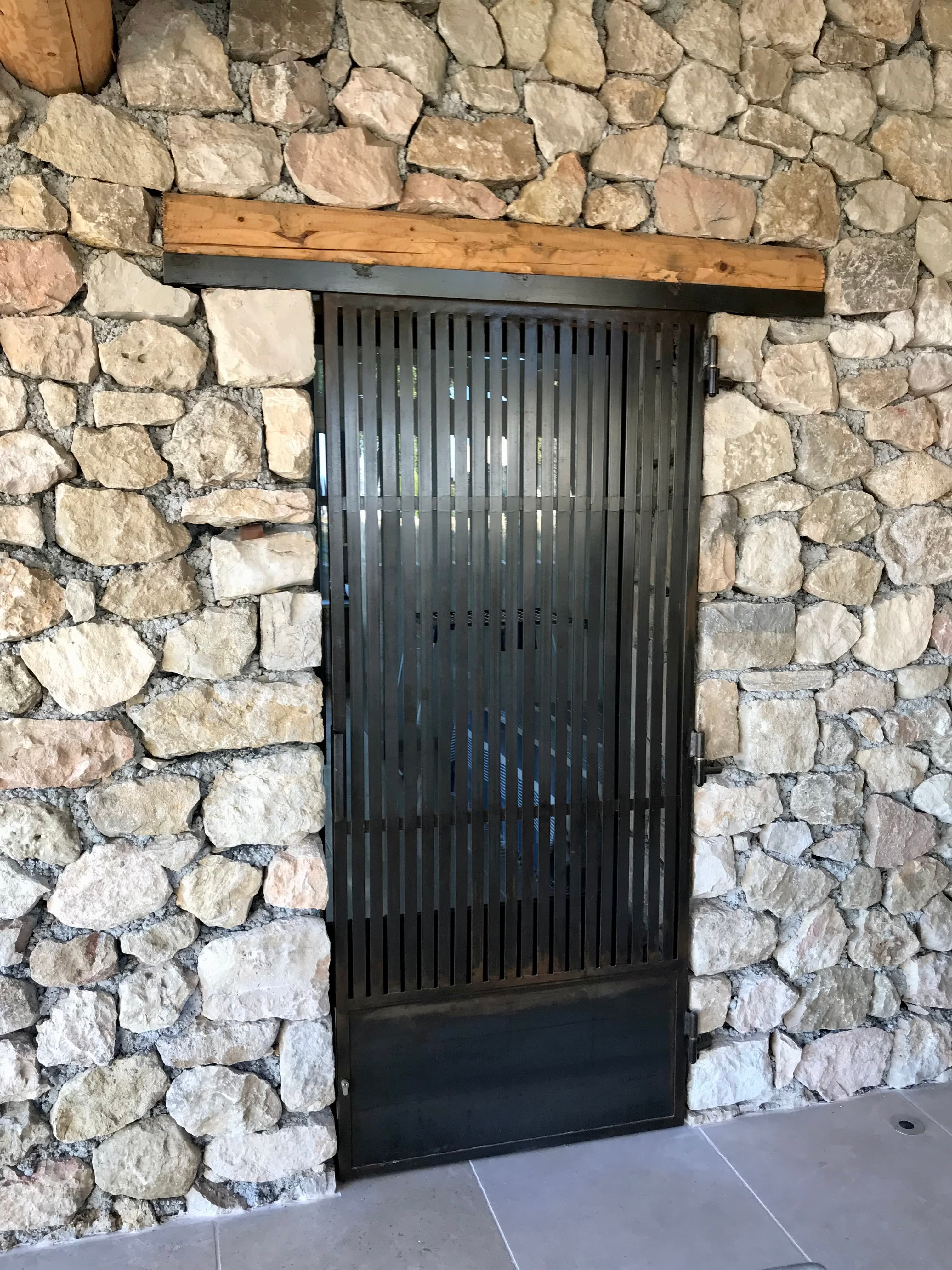 Porte métallique striée dans une façade en pierre